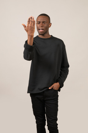 Young man standing and looking at his palm