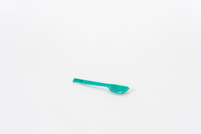 Plastic green spoon on a white background