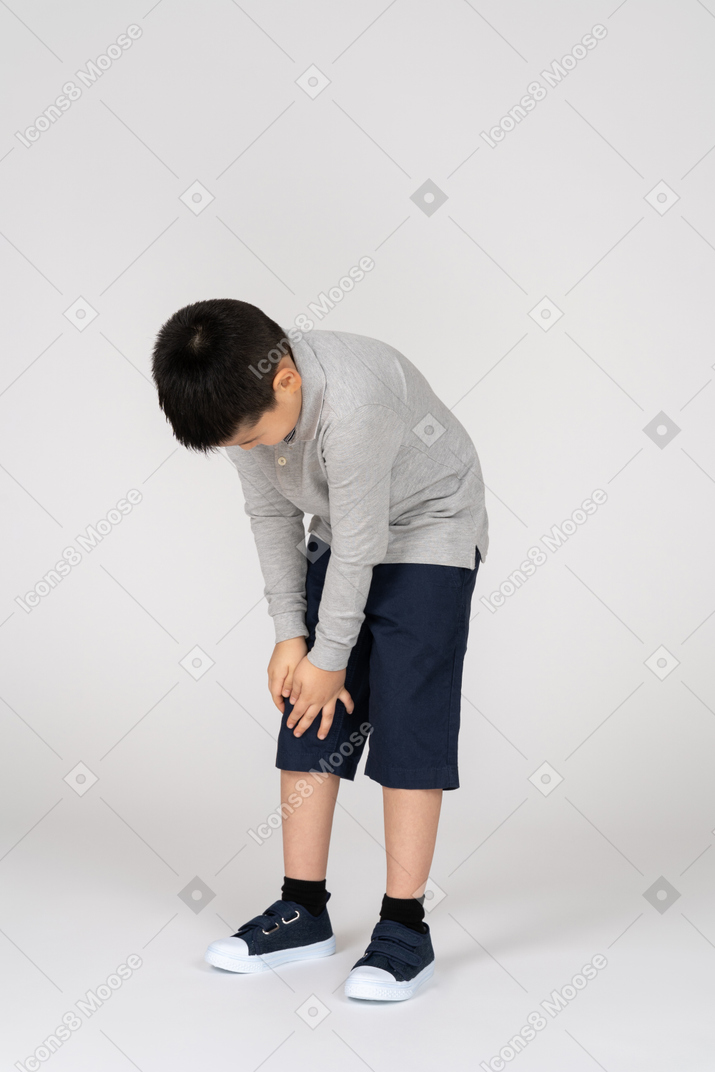 Niño con dolor sosteniendo su pierna
