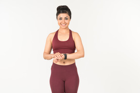 Indian girl in sporstwear checking fitness tracker