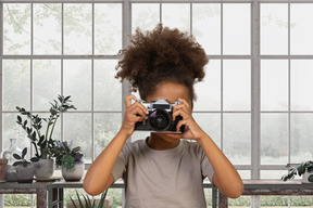 A little girl is taking a picture with camera