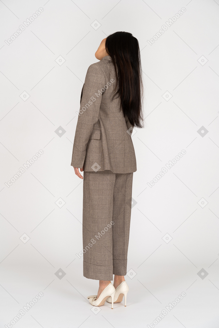 Vue arrière des trois quarts d'une jeune femme en costume brun tête inclinable