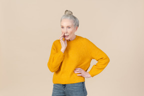 Mulher mais velha elegante em uma camisola de mostarda