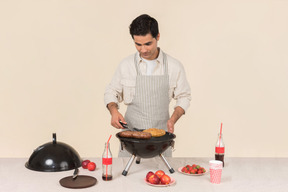 Joven hombre caucásico preparando barbacoa