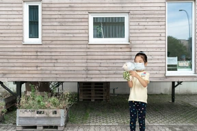Girl holding a soft toy wearing mask