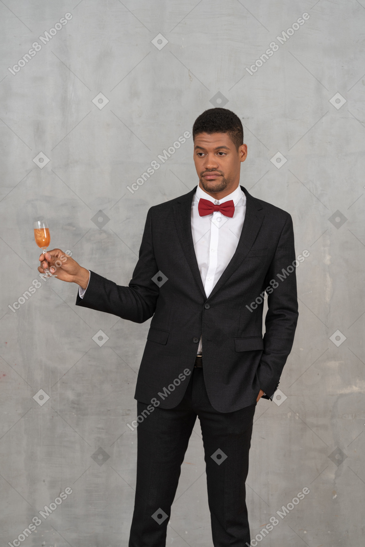 Man holding a glass of alcohol and looking unimpressed
