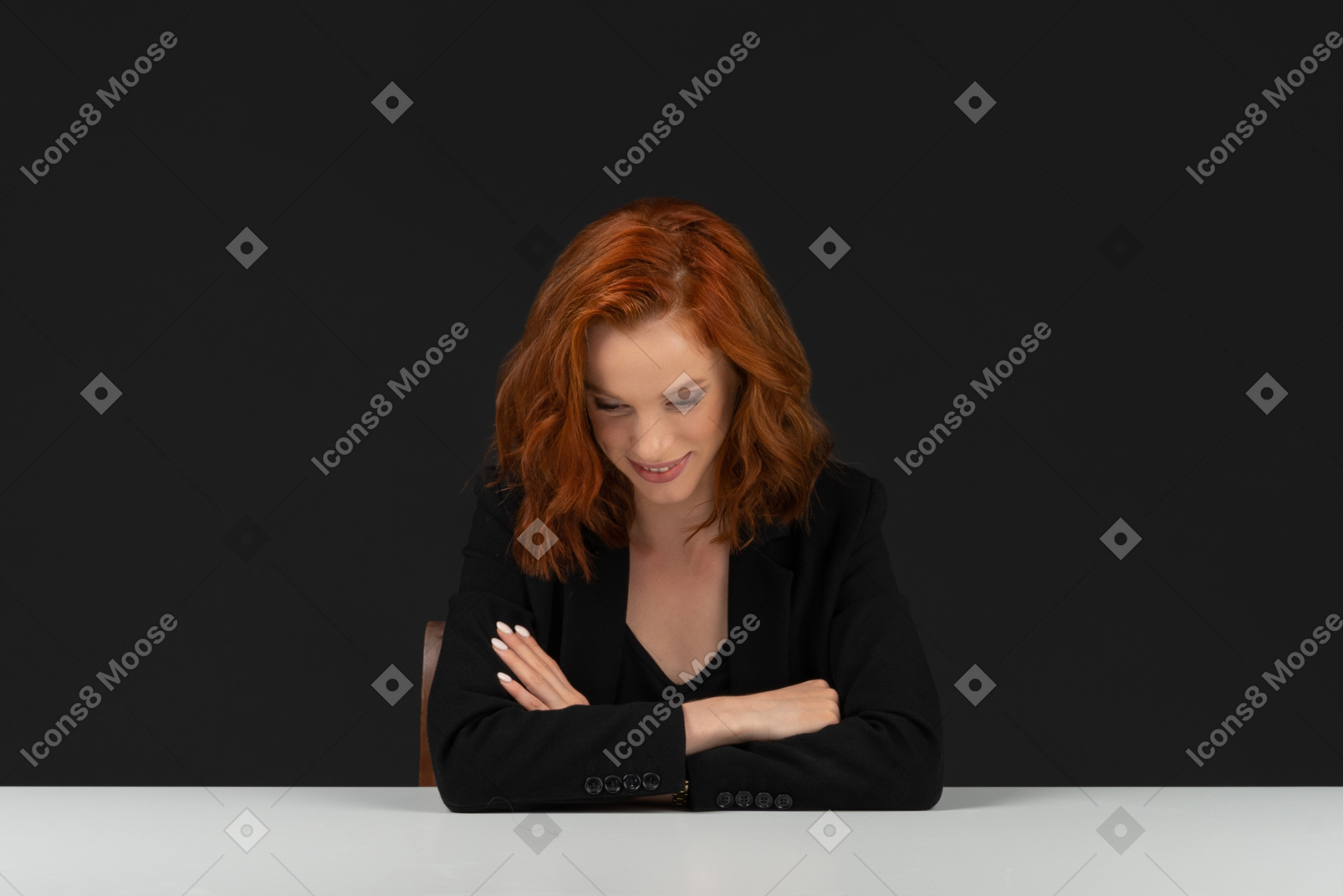 A frontal view of the beautiful girl sitting at the table and smiling