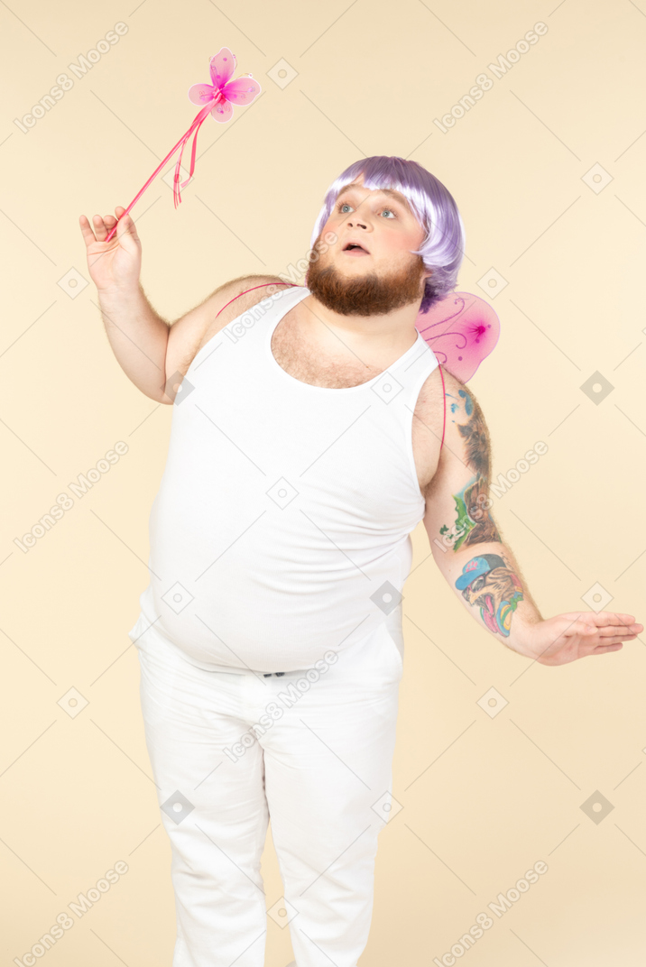 Dreamy young overweight man dressed as a fairy