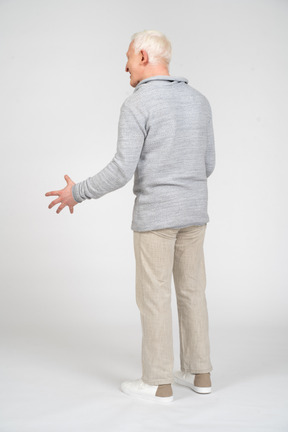 Back view of a man standing with open hand