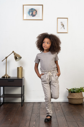 Good looking girl kid posing on the apartment background