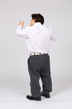 Back view of man pointing up