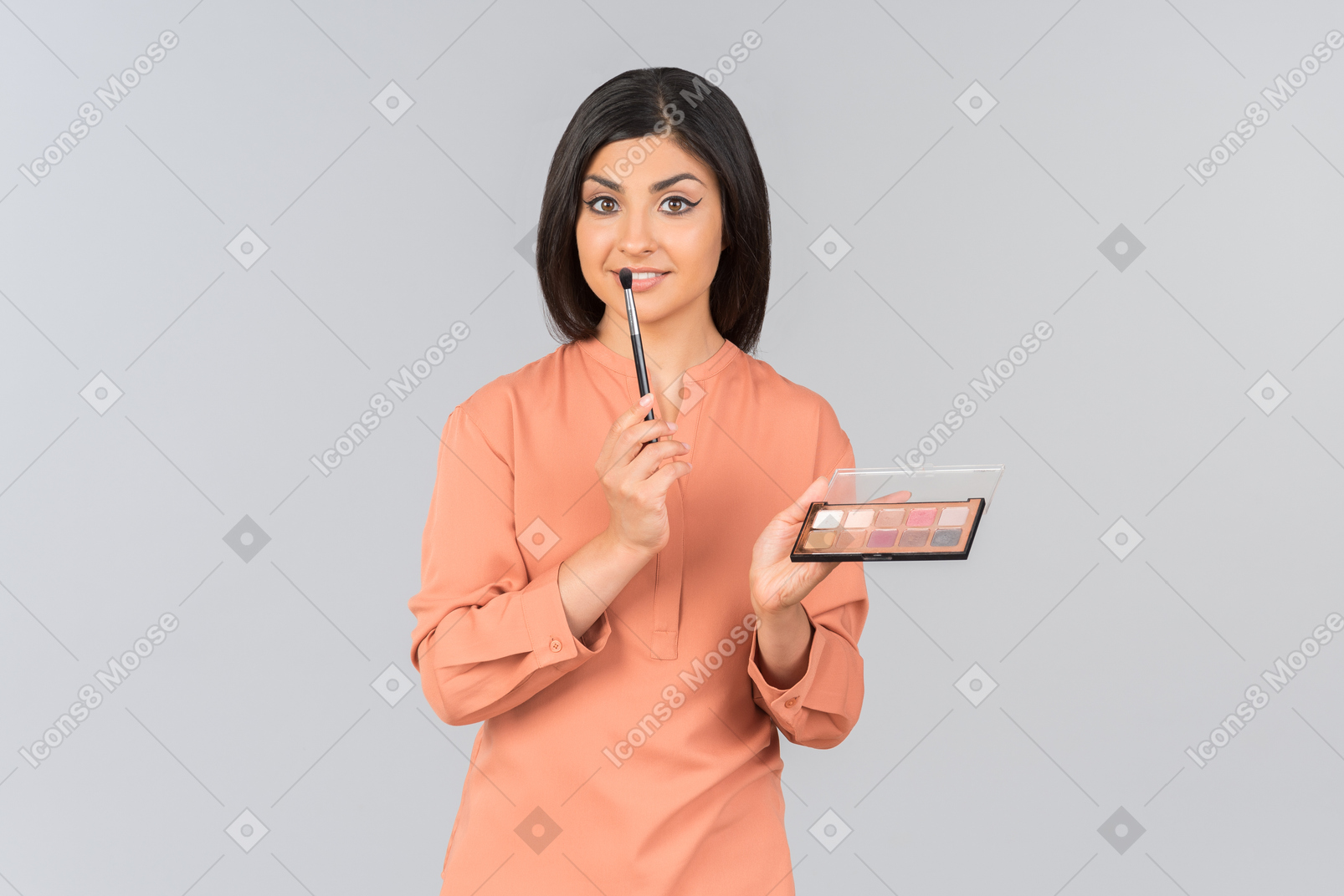 Mujer india apuntando a bálsamos labiales que está sosteniendo
