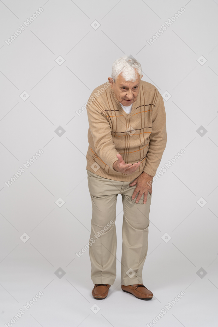 一位穿着休闲服的老人做欢迎手势的正面图