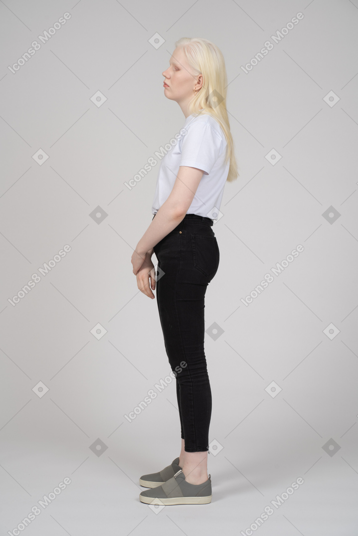 Vista di profilo di una donna bionda in abiti casual che guarda lontano