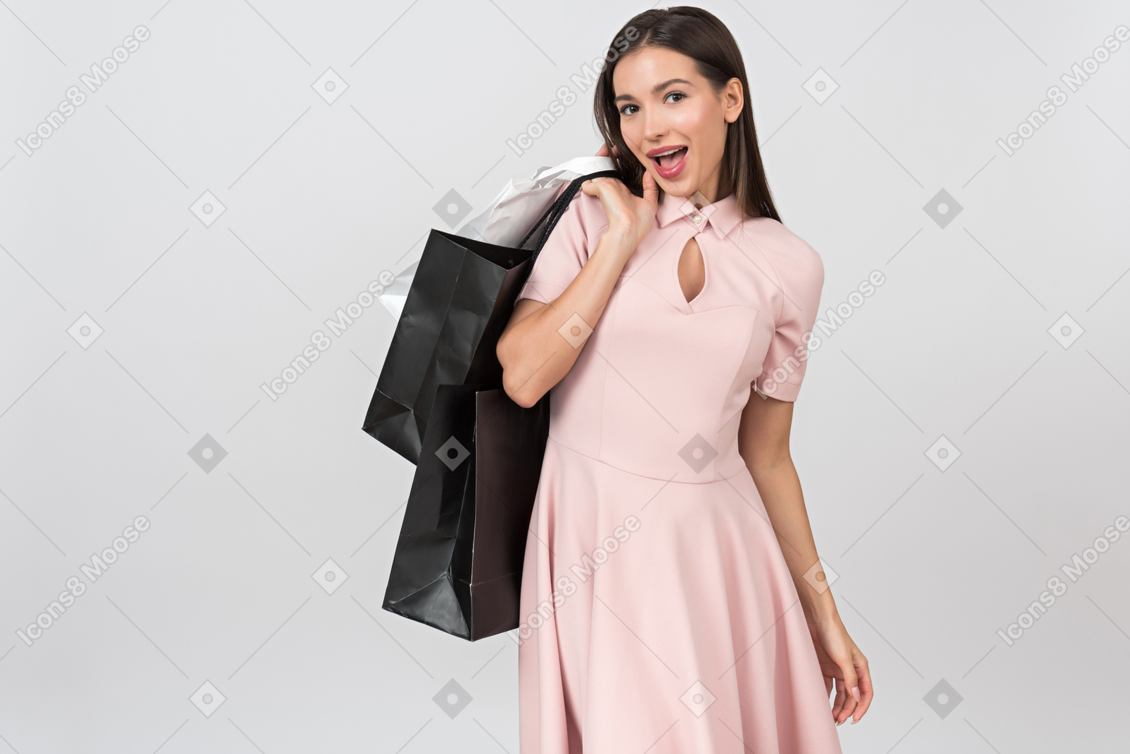 Mujer joven emocionada que sostiene bolsos de compras