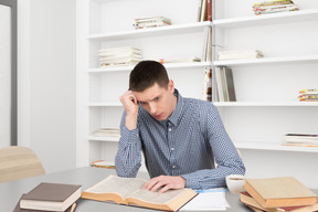 A man sitting at a table with an open book