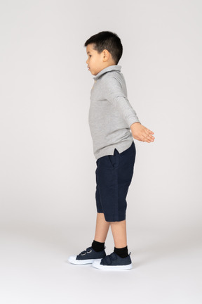 Boy with spread arms in profile