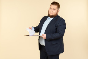 Overweight male office worker revising papers