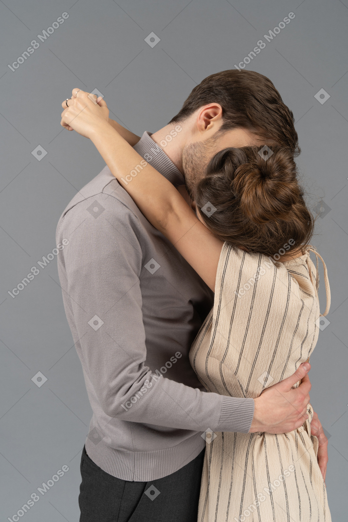 Couple kissing with arms around each other