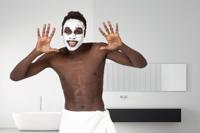 Happy man with facial mask showing his palms