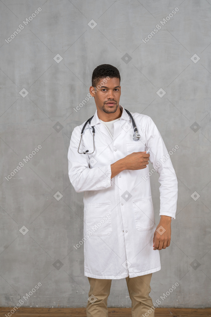Médico varón tocando el bolsillo de su abrigo