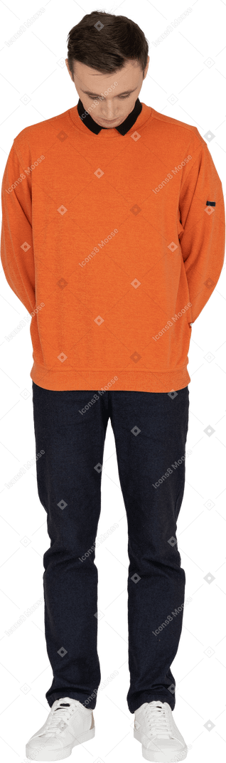 Junger mann im orangefarbenen sweatshirt stehend