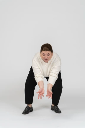 Front view of a plump woman in casual clothes squatting