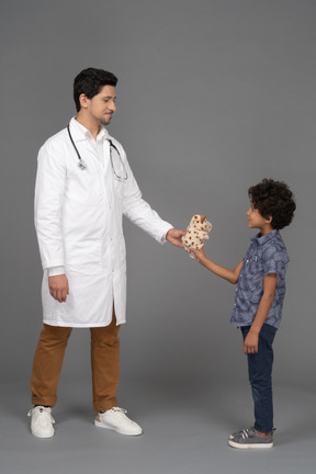 Arzt gibt kleinem kind ein spielzeug
