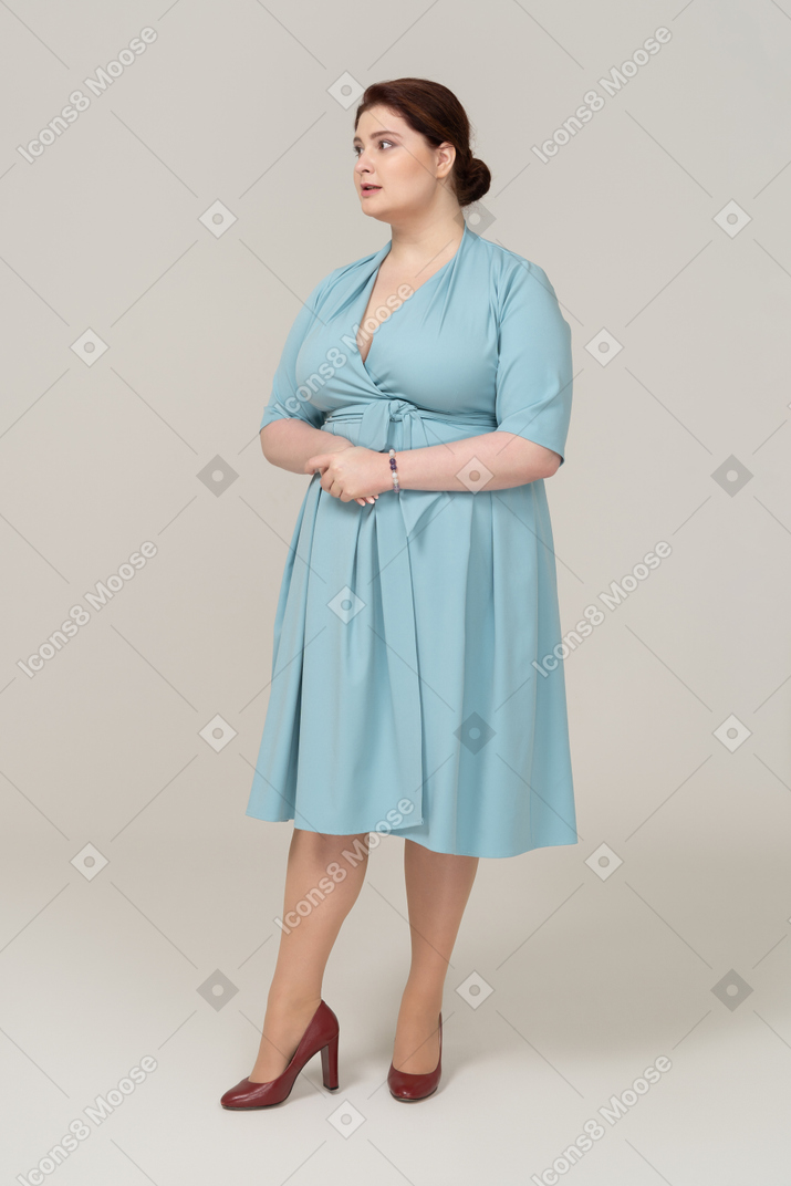 一个穿着蓝色连衣裙的女人看着相机的前视图