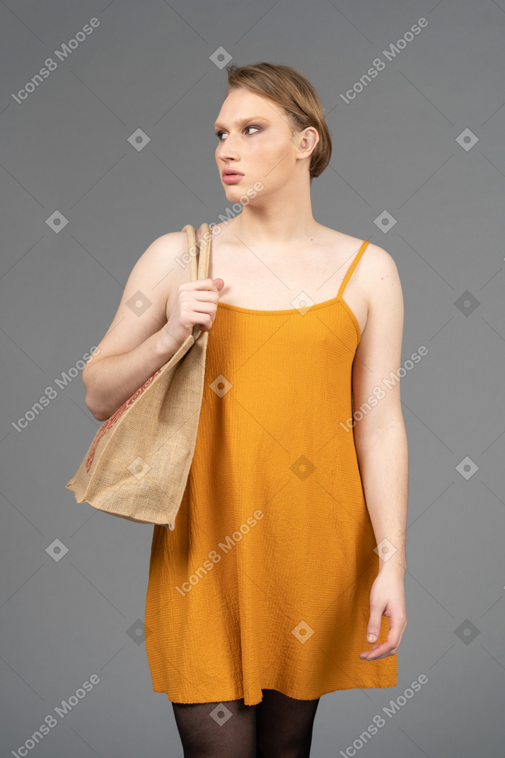 Retrato de una persona joven que camina y lleva una bolsa