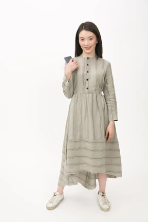 Girl in long grey dress holding a smartphone