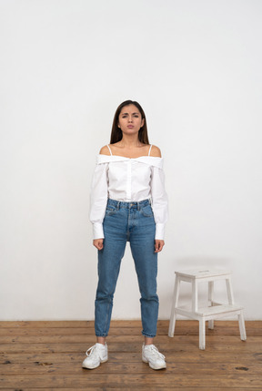 A woman standing in front of a white wall