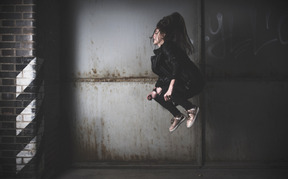 Side view of a young girl jumping high