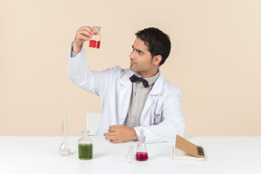 Homme scientifique assis à la table et regardant la table