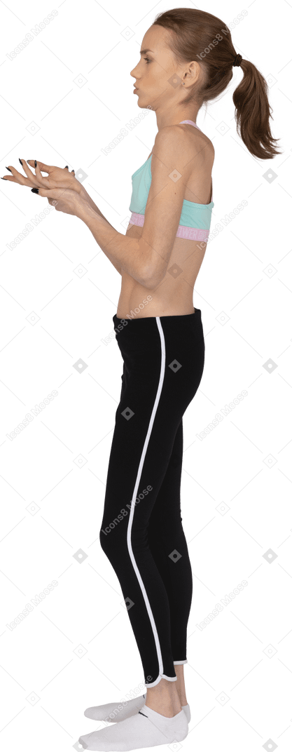 Side back view of a careless teen girl in sportswear holding hands together