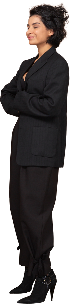 Вид в три четверти на бизнесвумен в черном костюме, обнимающую себя с закрытыми глазами