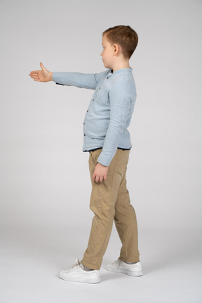 Vista lateral de um menino dando uma mão para apertar