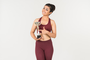 Jeune femme indienne en sporstwear pointant sur le prix qu'elle tient