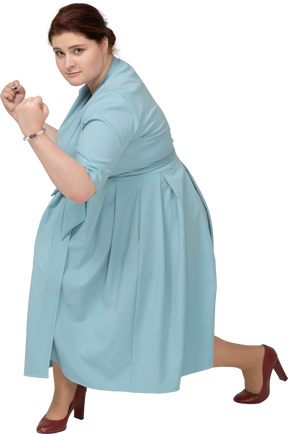 Vista frontal de uma mulher de vestido azul se exercitando