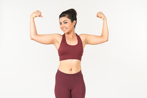 Индийская женщина в спортивной одежде, показывая мышцы