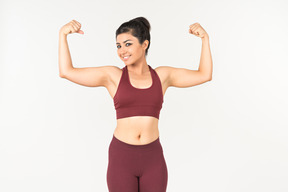 Indian woman in sportswear showing muscles