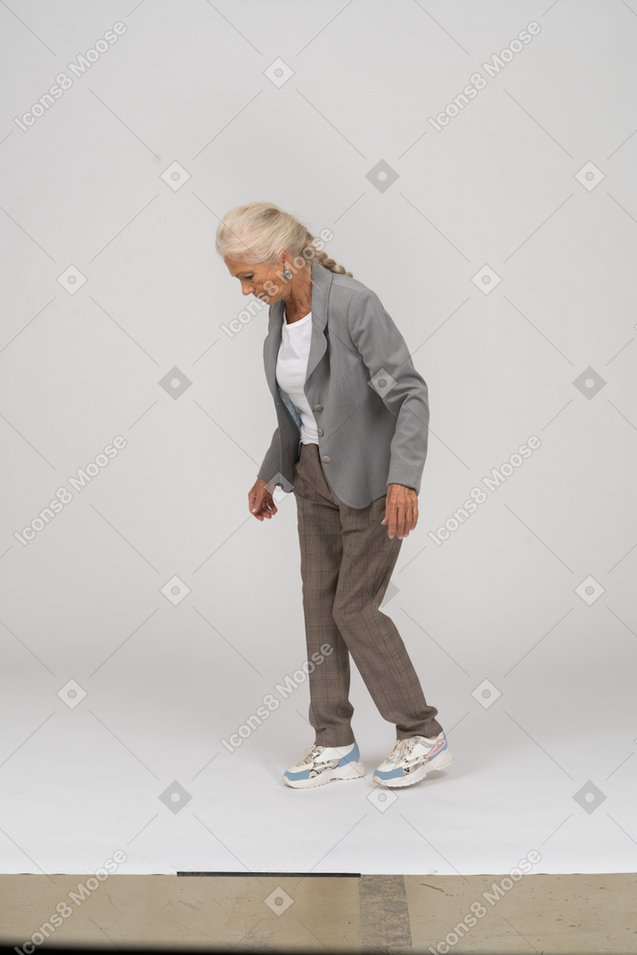 Side view of an old lady in suit looking down