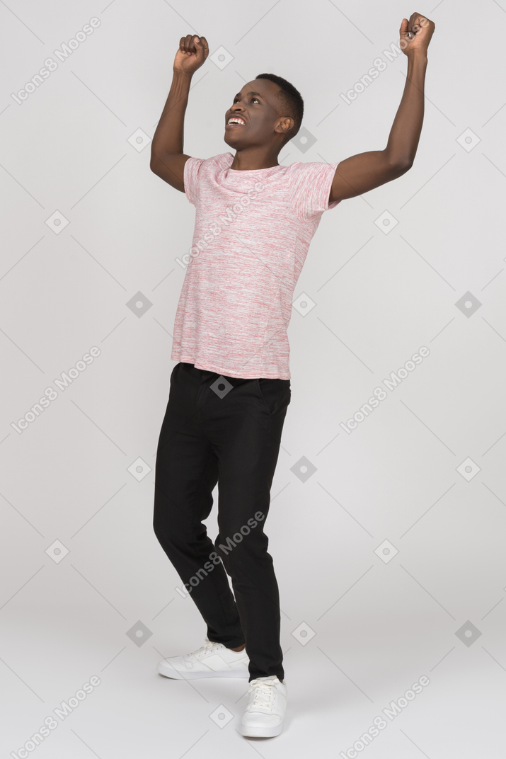 Young man raising his arms to celebrate his success