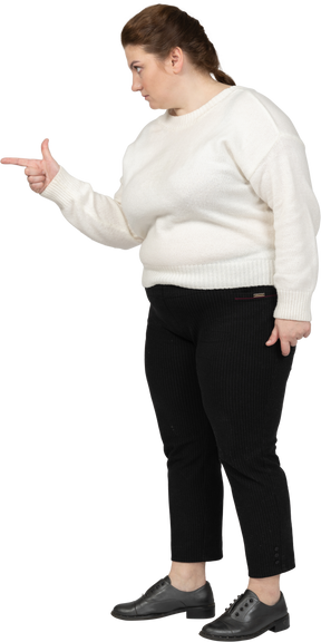 Side view of a plump woman in casual clothes pointing with a finger