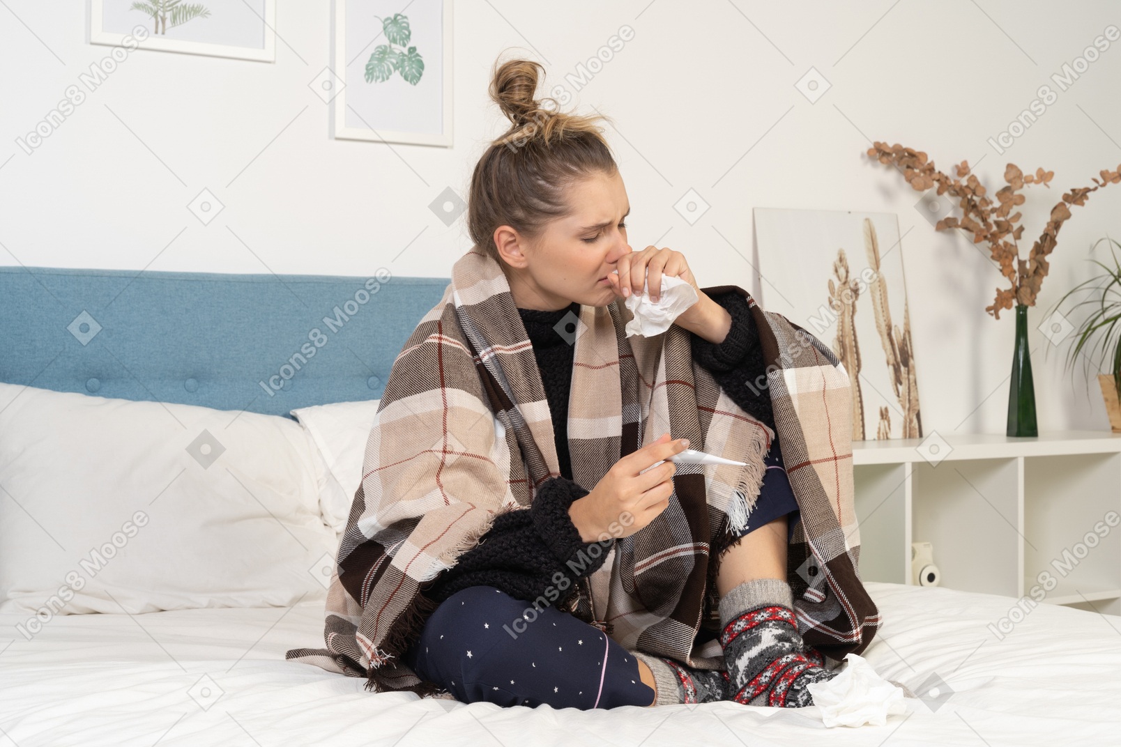 一位身着睡衣、裹着格子毯子的生病年轻女士的侧视图，正在检查她的体温