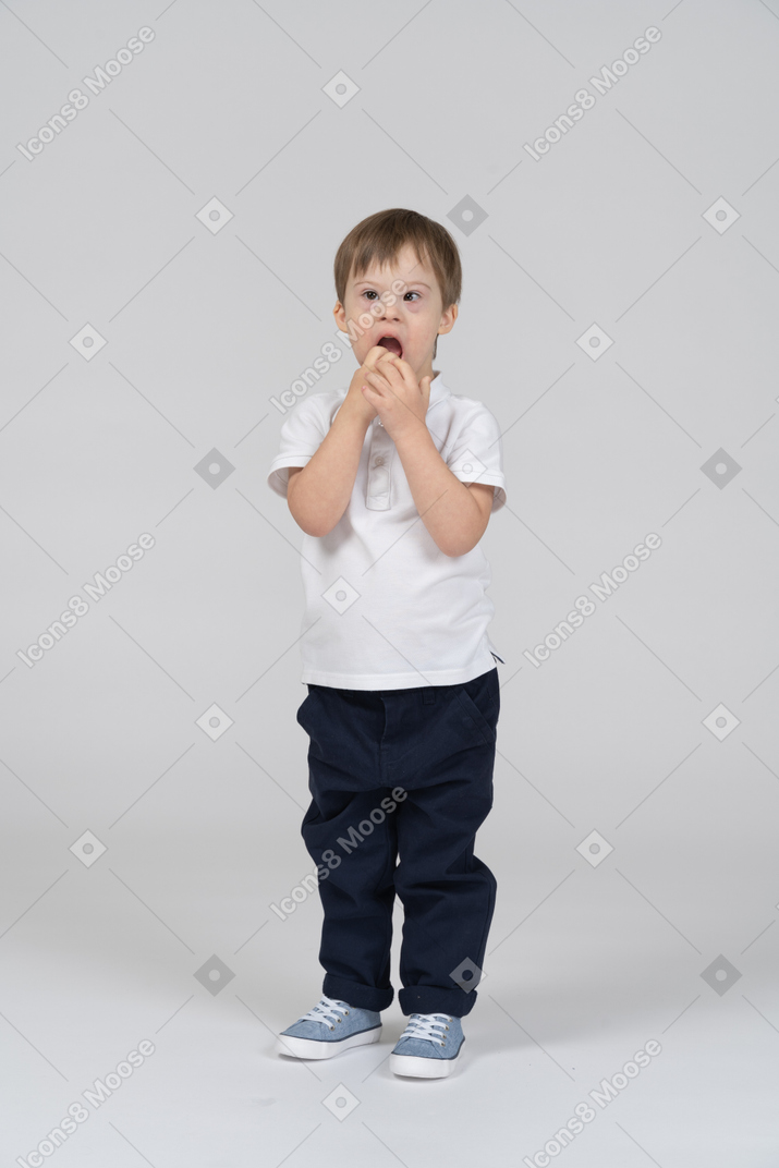 Surprised little boy covering his mouth