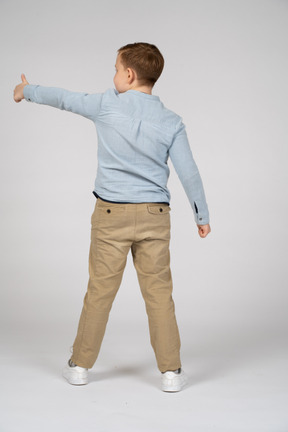 親指を上に表示している男の子の背面図