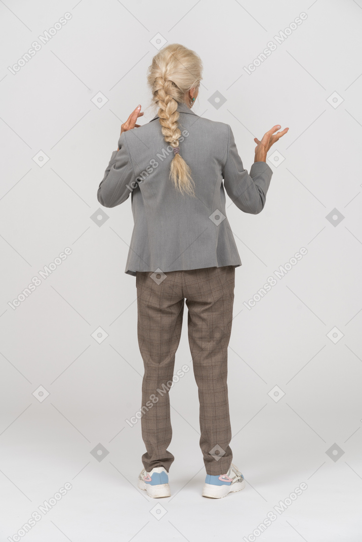 Back view of an old lady in suit explaining something