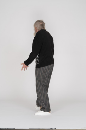 Back view of old man with spread arms