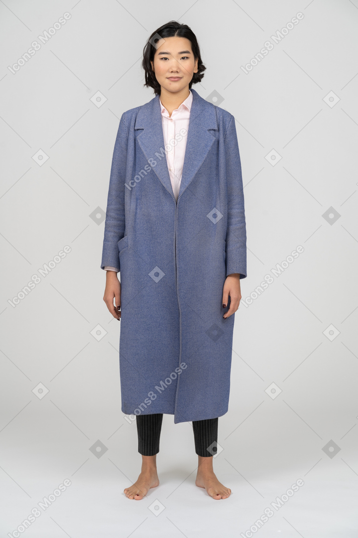 Вид спереди улыбающейся женщины в синем пальто